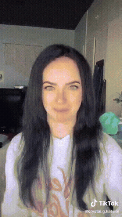 Woman With Long Black Hair In White Shirt Saying Love GIF