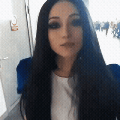 Woman With Long Black Hair In White Shirt Wearing Mask GIF