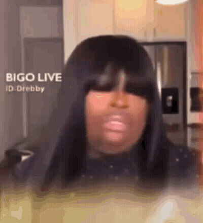 Woman With Long Black Hair Making Funny Face In Kitchen GIF