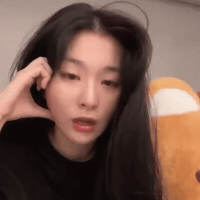Woman With Long Black Hair Making Phone Call Holding Stuffed Animal GIF
