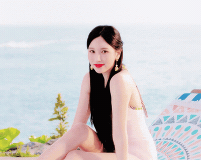 Woman With Long Black Hair Sitting Near Ocean GIF
