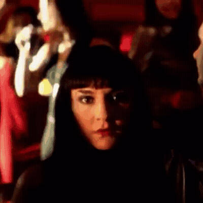 Woman With Long Black Hair Standing In Front Of Crowd GIF