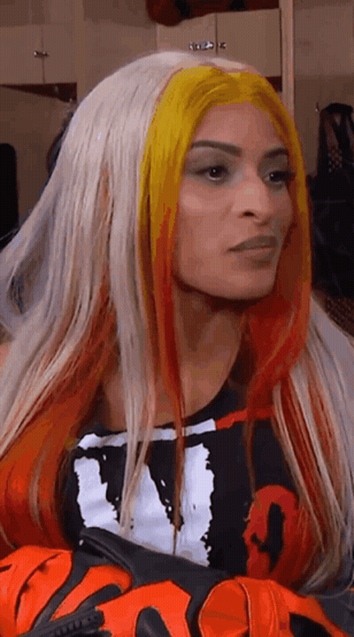 Woman With Long Blonde And Red Hair In Black And White Shirt And Gloves GIF
