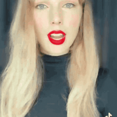 Woman With Long Blonde Hair And Red Lips In Black Turtleneck GIF