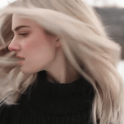 Woman With Long Blonde Hair In Black Sweater GIF