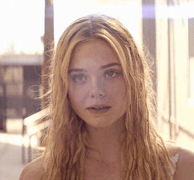 Woman With Long Blonde Hair Looking At Camera GIF