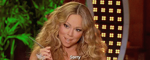 Woman With Long Blonde Hair Sitting In Front Of Green Screen Saying Sorry GIF