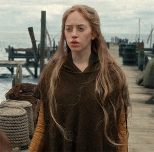 Woman With Long Blonde Hair Wearing Brown Poncho GIF
