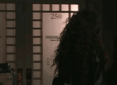 Woman With Long Curly Hair In Front Of Door Saying 250 GIF