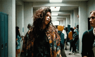 Woman With Long Curly Hair In Hallway With Lockers GIF