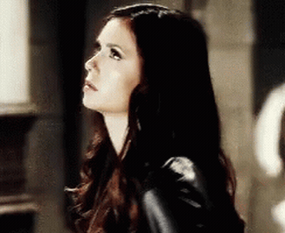 Woman With Long Dark Hair In Black Jacket Looking Up GIF