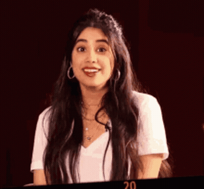 Woman With Long Dark Hair In White Shirt And Earrings GIF