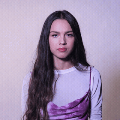 Woman With Long Dark Hair In White Shirt And Purple Dress GIF