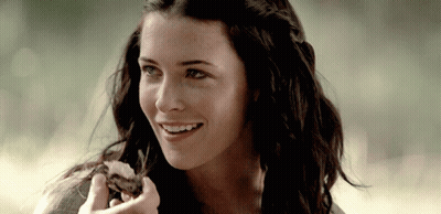 Woman With Long Dark Hair Smiling Holding Food GIF