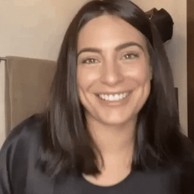 Woman With Long Dark Hair Smiling In Bathroom GIF