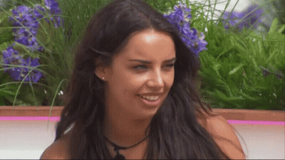 Woman With Long Dark Hair Smiling Purple Flowers GIF