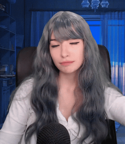 Woman With Long Grey Hair Sitting At Microphone Eyes Closed GIF