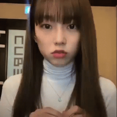 Woman With Long Hair And Bangs In White Turtleneck And Necklace GIF