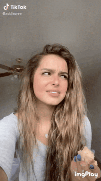 Woman With Long Hair And Blue Nail Polish Holding Food GIF