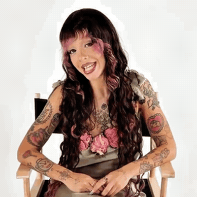 Woman With Long Hair And Many Tattoos Sitting GIF