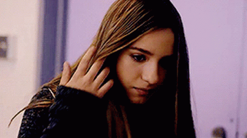 Woman With Long Hair Holding Hand To Head GIF