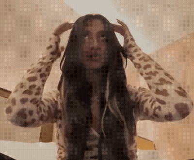 Woman With Long Hair In Leopard Print Sweater Holding Head GIF