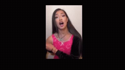 Woman With Long Hair In Pink Shirt And Necklace Saying Robertooooo GIF