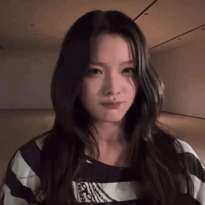 Woman With Long Hair In Striped Shirt Looking At Camera GIF