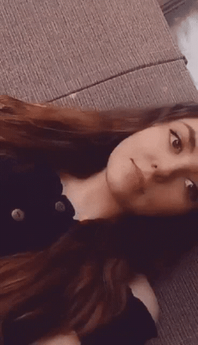Woman With Long Hair Laying On Couch Making Face GIF