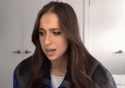Woman With Long Hair Making Funny Face In Leather Jacket And Necklace GIF