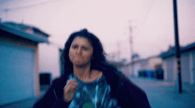 Woman With Long Hair Running Down Street GIF