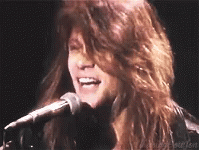Woman With Long Hair Singing Into Microphone