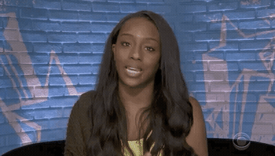 Woman With Long Hair Sitting In Front Of Brick Wall GIF