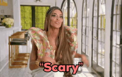 Woman With Long Hair Sitting In Front Of Window Saying Scary GIF