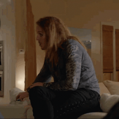 Woman With Long Hair Sitting On Couch Holding Glass GIF