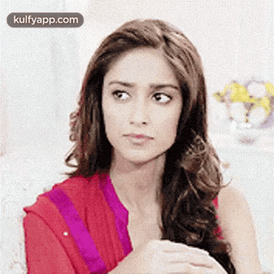 Woman With Long Hair Sitting On Couch Looking At Camera GIF