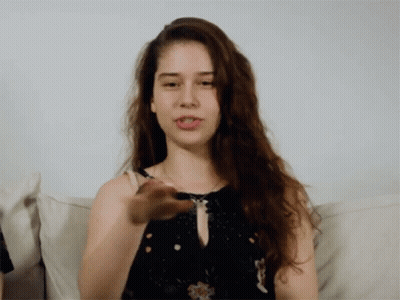 Woman With Long Hair Sitting On White Couch GIF