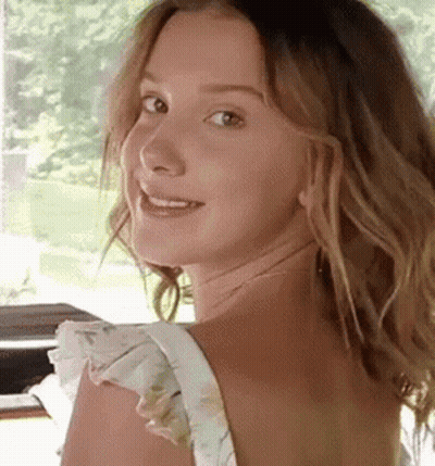 Woman With Long Hair Smiling Over Shoulder GIF