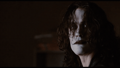 Woman With Long Hair Standing Before Bookshelf GIF