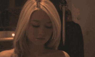 Woman With Long Hair Standing in Front of Candle in Dark Room
