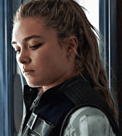 Woman With Long Hair Standing In Front Of Window Wearing Vest GIF