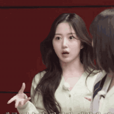 Woman With Long Hair Talking To Another Woman In Front Of Red Background GIF