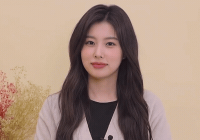 Woman With Long Hair Waving Hands In Front Of Yellow Wall GIF