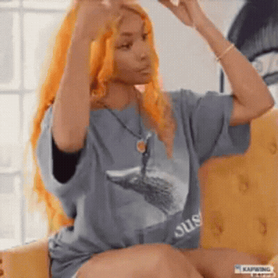 Woman With Long Orange Hair Hands In Hair On Couch GIF
