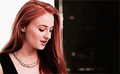 Woman With Long Red Hair In Black Top And Gold Necklace GIF