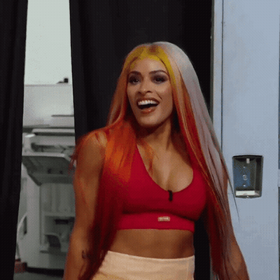 Woman With Long Red Hair In Red Sports Bra Smiling GIF