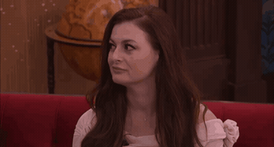Woman With Long Red Hair On Red Couch With Globe GIF
