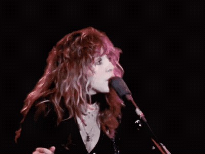 Woman With Long Red Hair Singing Into Microphone GIF