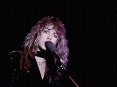 Woman With Long Red Hair Singing Into Microphone GIF