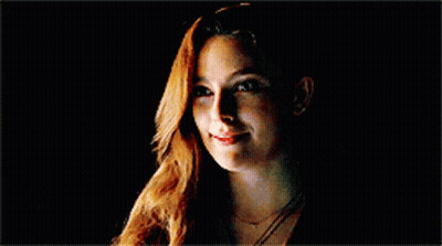 Woman With Long Red Hair Smiling In Dark GIF